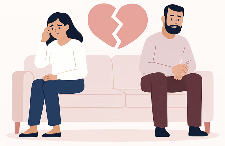 Couple sitting apart on couch with broken heart